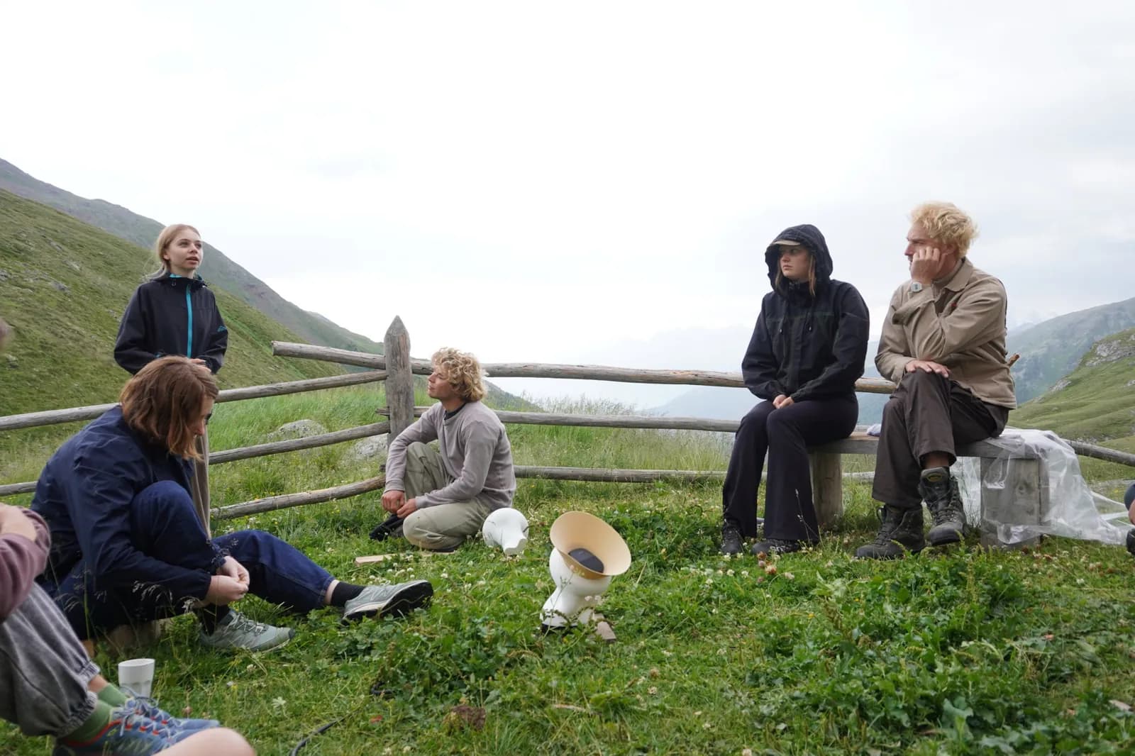 People sitting in the grass on a mountain pass around the Entity, its white horn speakers in the foreground.